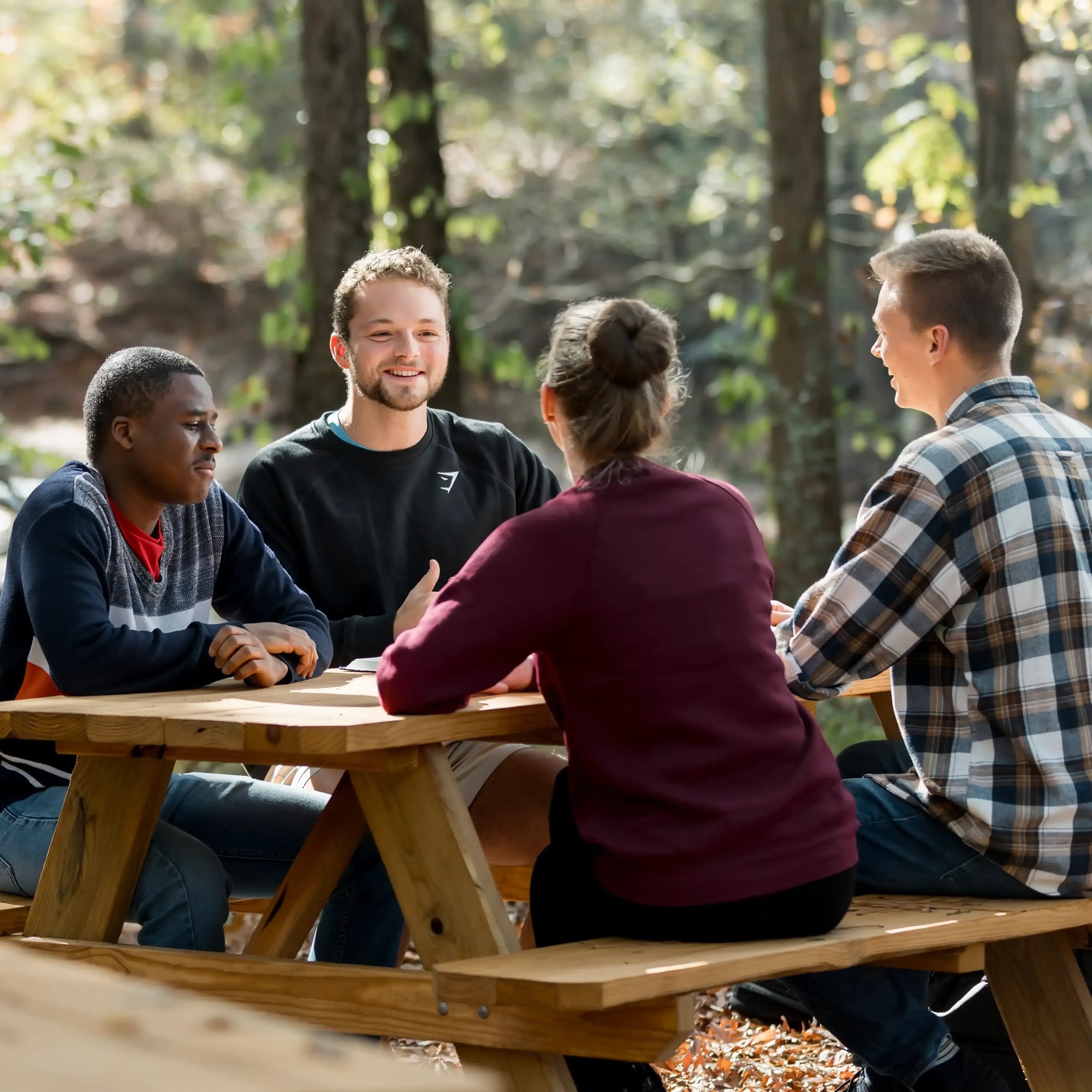RTS students sitting outside on a bench smiling together