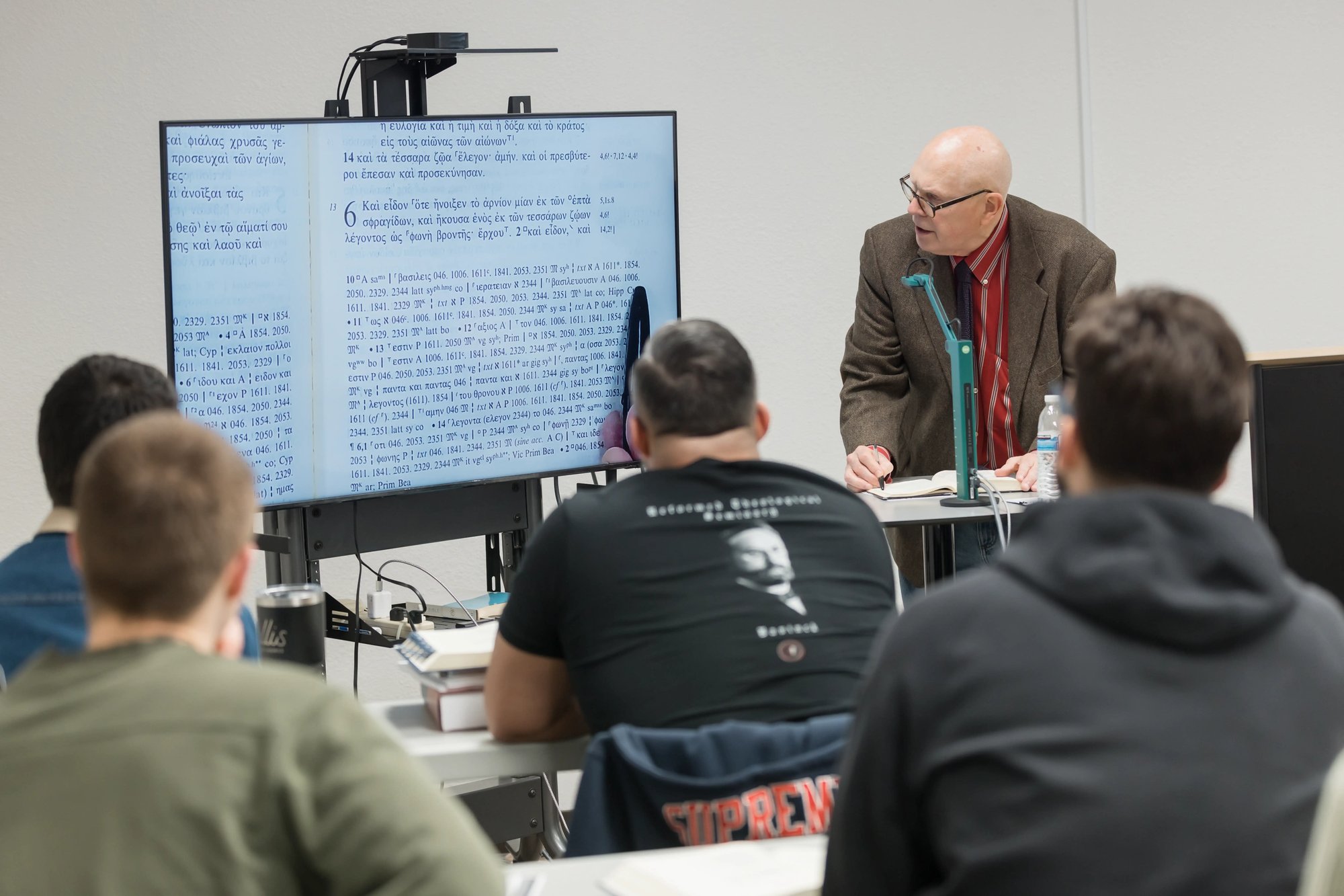 Group of students sitting in class watching professor give lecture