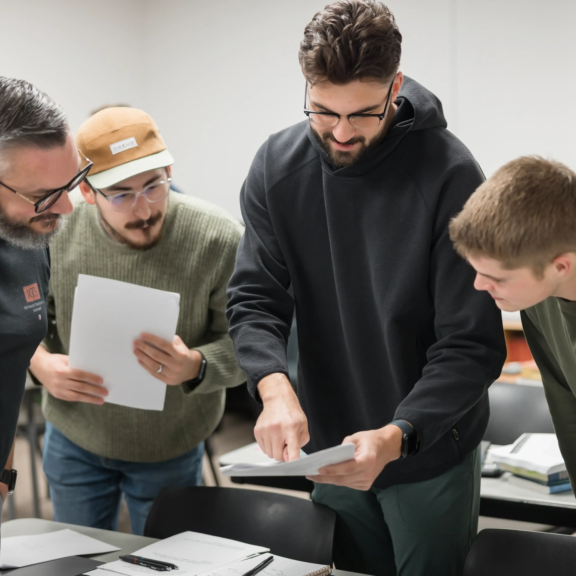 Students standing together looking at study notes