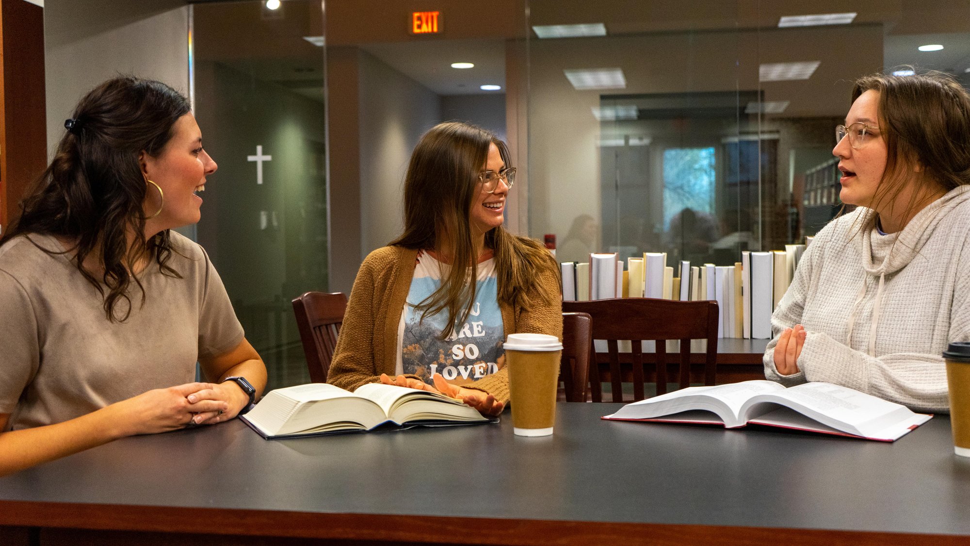 Women sitting at table studying together and laughing