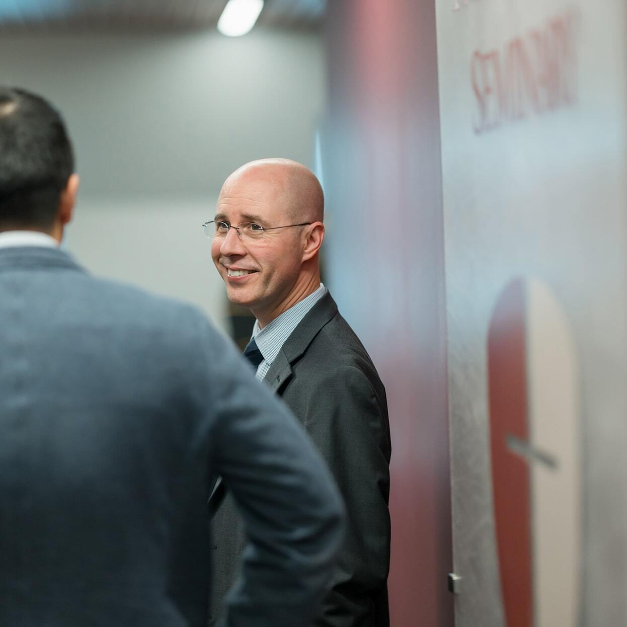 Faculty member smiling while talking with another person in a hallway at Reformed Theological Seminary.