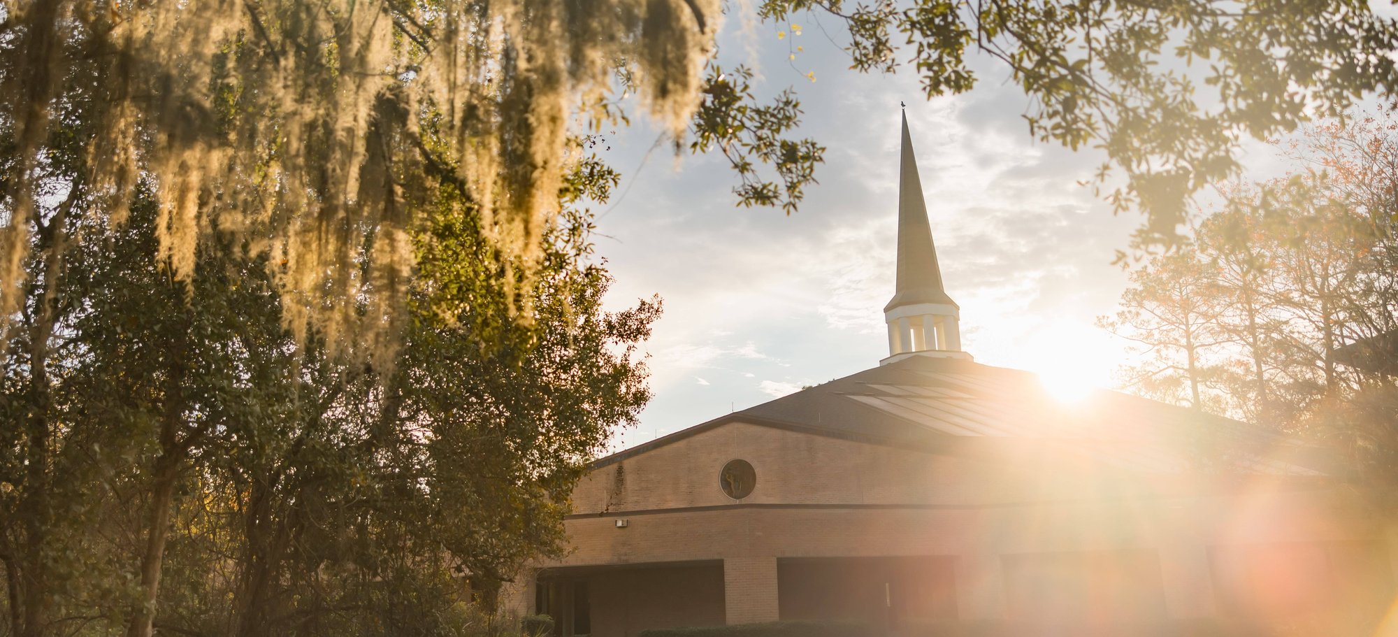 RTS Orlando campus chapel exterior at sunrise with trees and sunlight
