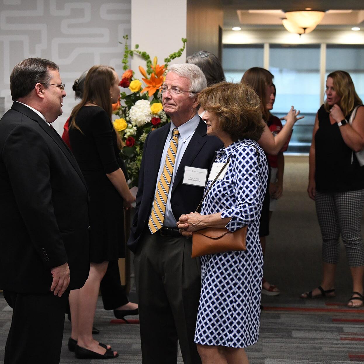 Guests conversing and networking at an indoor open house event during a professional reception