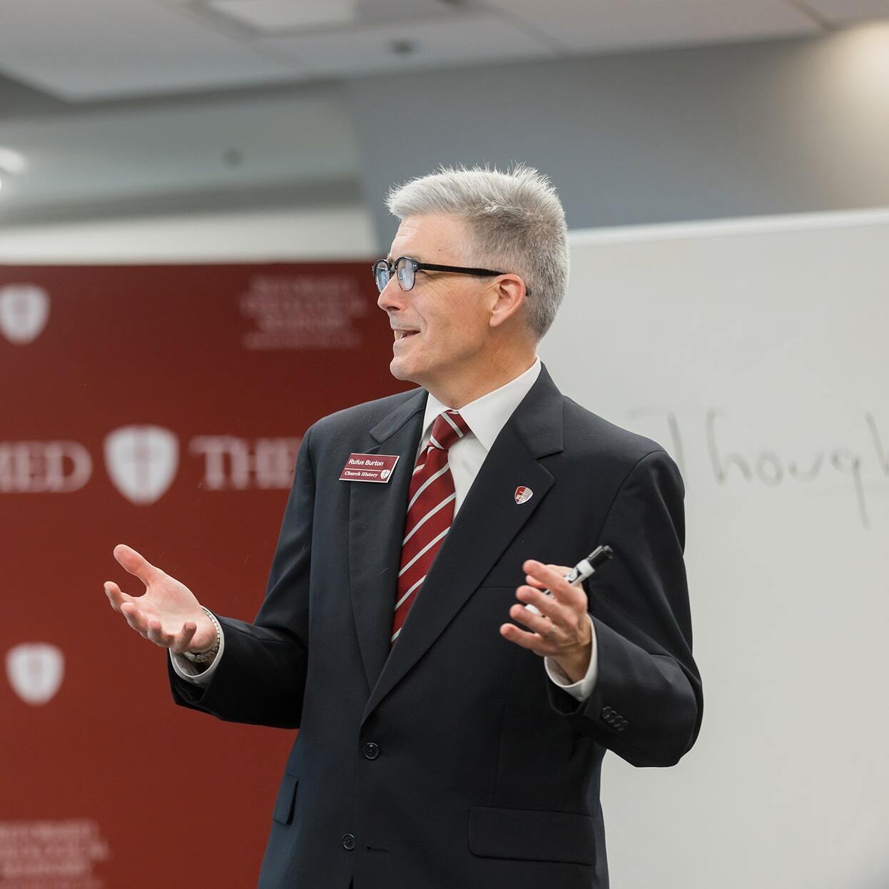 Professor speaking and gesturing while teaching in a classroom setting at Reformed Theological Seminary.