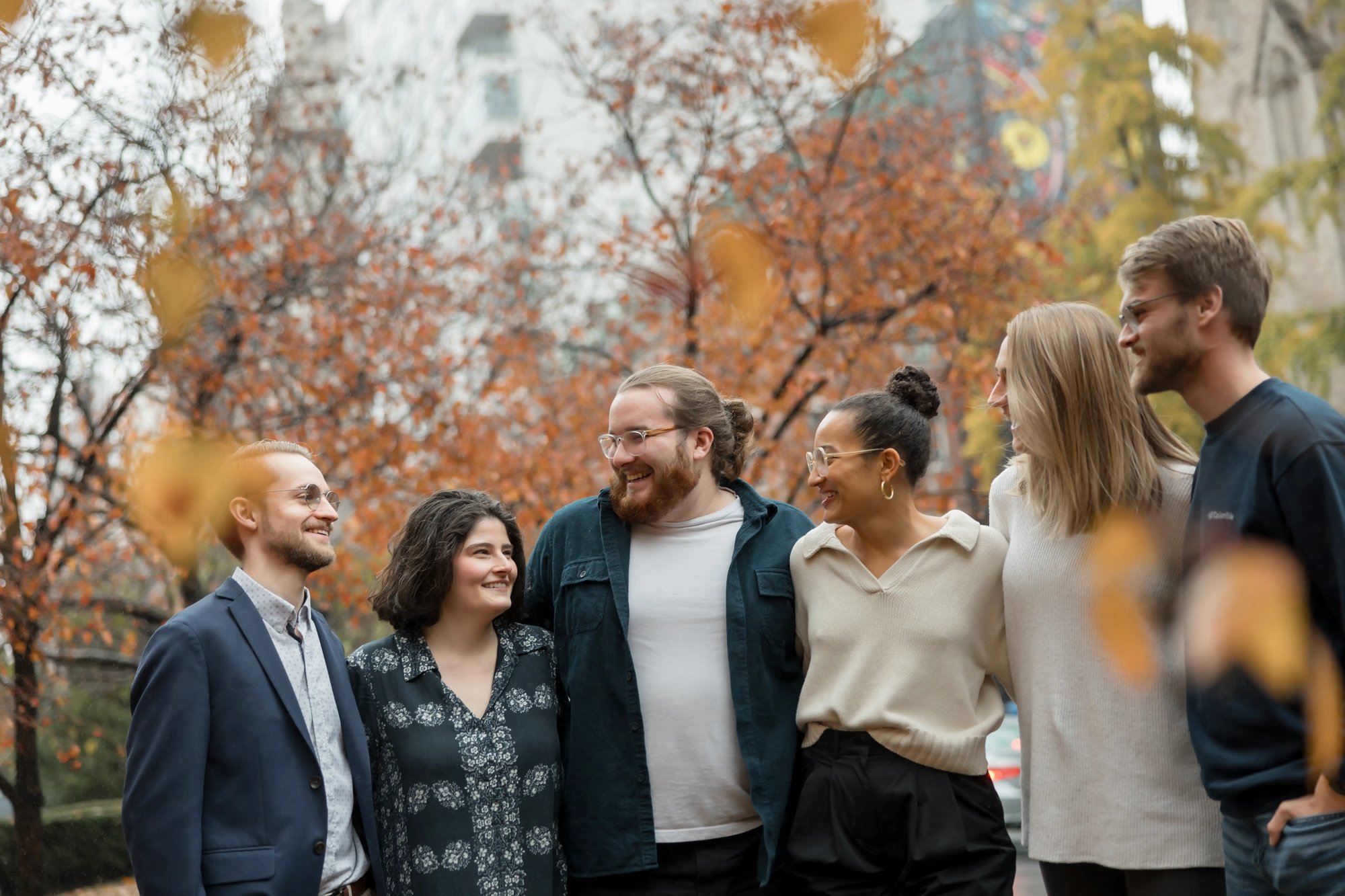 Group of people standing together outdoors in a city park during autumn