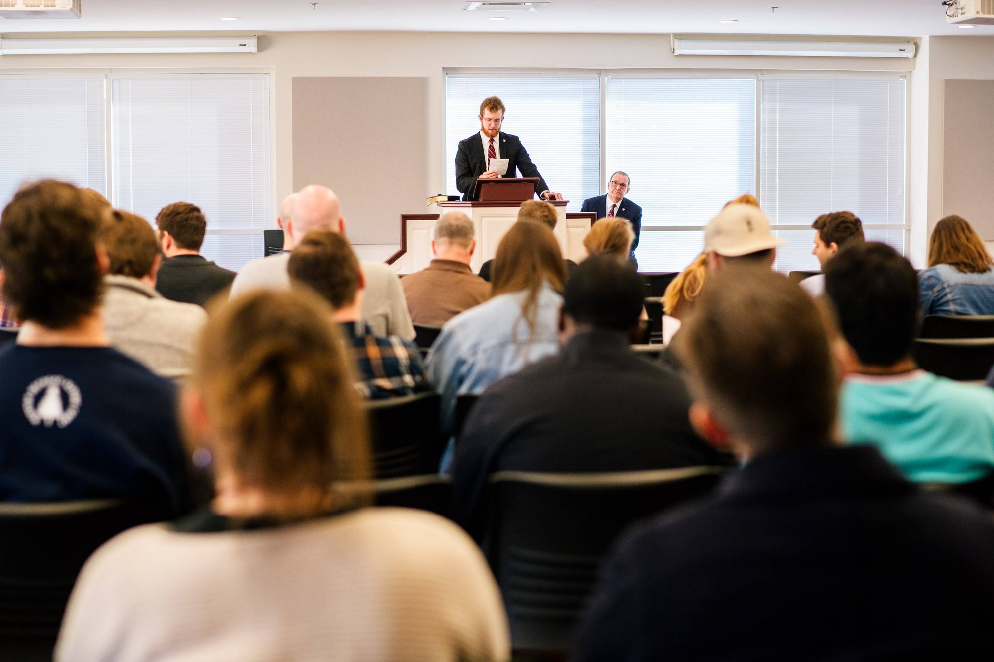Speaker presenting to students seated in a lecture hall.