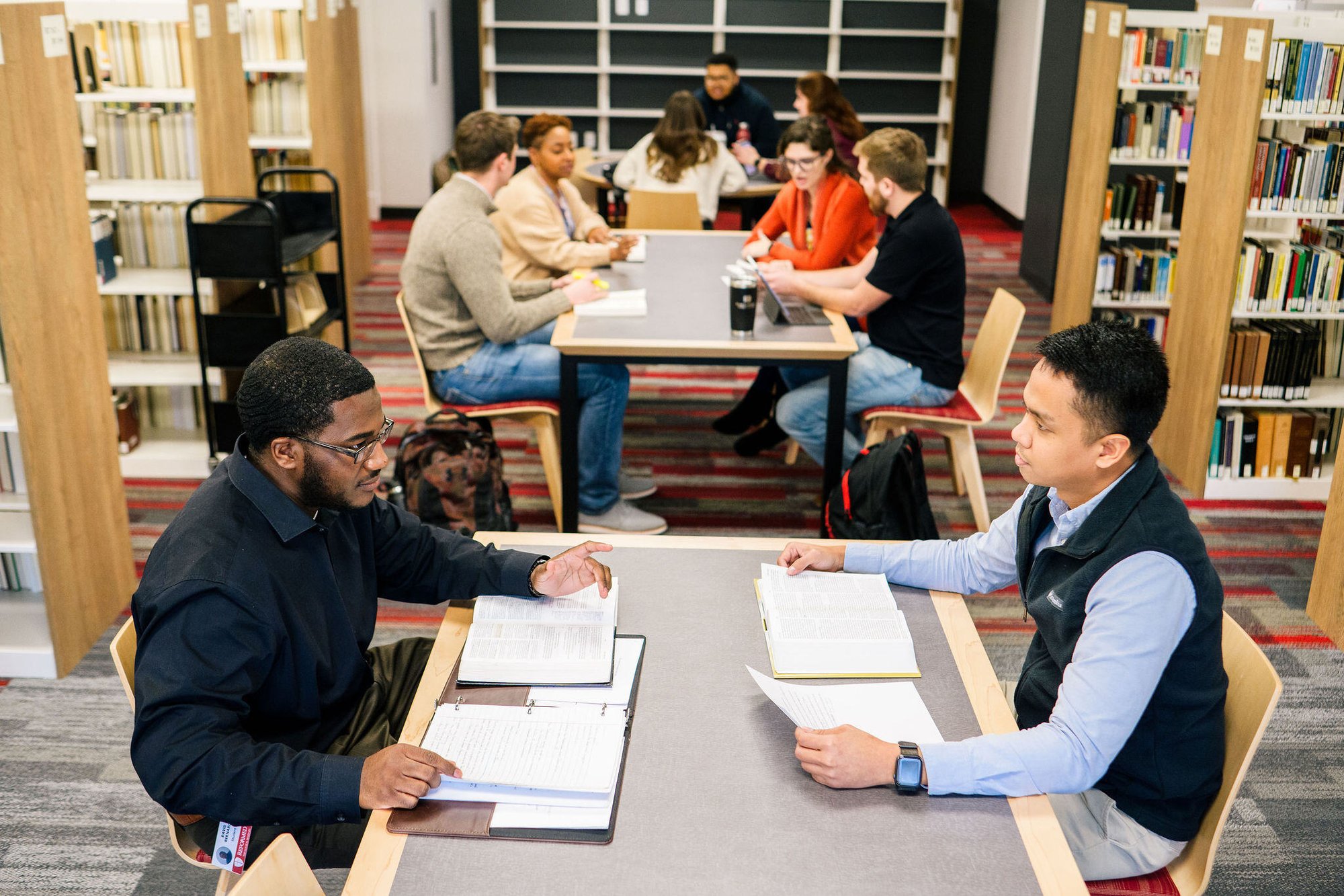 Students studying together at tables in the library.