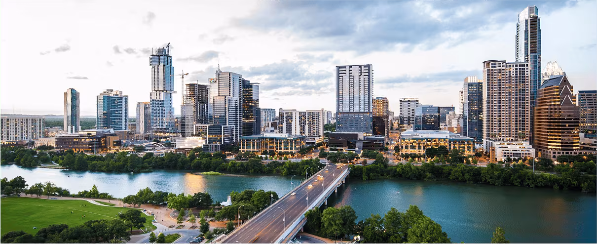 Panoramic view of the Austin skyline with Lady Bird Lake and a bridge in the foreground
