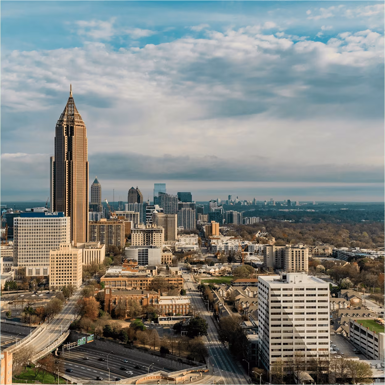 Atlanta skyline with Midtown high-rises and highways under a cloudy sky